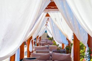 Beyaz plaj gölgelikleri. Bir tatil beldesinde lüks plaj çadırları