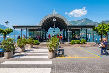Bellagio, Italya-3 Mayıs 2018: Como Gölü üzerinde ünlü bir tatil kasabası olan Bellagio 'da bir iskele. Turistler feribot tekne yakalamak için beklemek