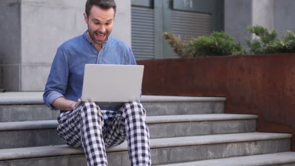 Casual Man viert zege op Laptop zitting op trappen — Stockvideo
