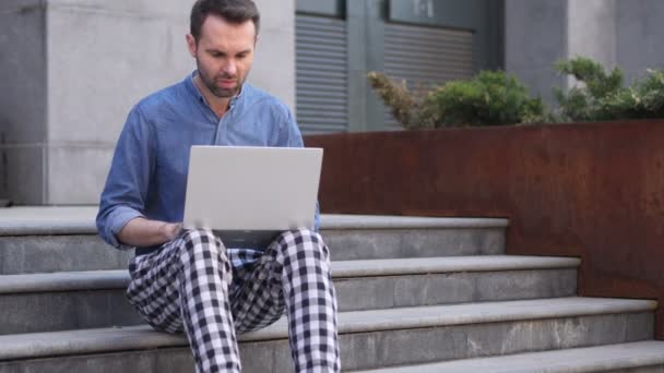 Verlust, Mann frustriert über Ergebnisse auf Laptop, während er auf der Treppe sitzt — Stockvideo