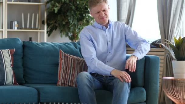 Mann Mittleren Alters Sitzt Mit Knieschmerzen Auf Couch — Stockvideo