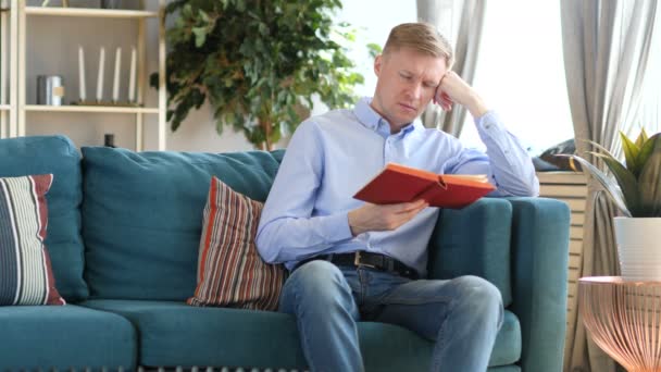 Schlafender Mann Mittleren Alters Hält Buch Während Auf Dem Sofa — Stockvideo