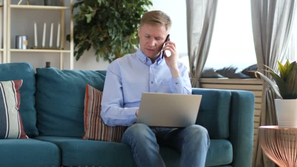 Hombre Mediana Edad Hablando Por Teléfono Trabajando Ordenador Portátil — Vídeo de stock