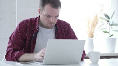 Üzgün kızgın genç adam Office içinde Laptop üzerinde çalışıyor