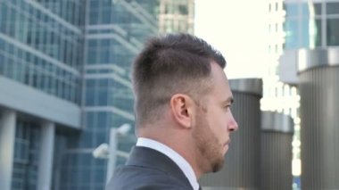 Sokakta yürüyen genç işadamı yan görünüm