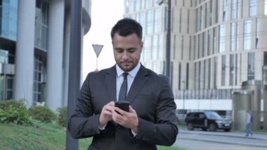 İşadamı heyecanlı Smartphone kullanarak süre başarı için yürüyüş