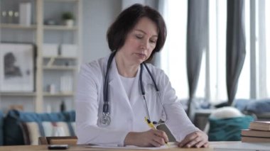Yaşlı kadın doktor yazma tıbbi rapor, evrak