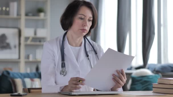 Anciana Doctora Leyendo Informe Médico Papeleo — Vídeo de stock