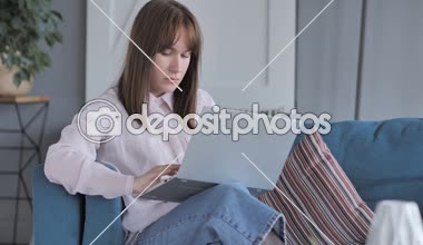 Rahat oturan genç kız evde dizüstü bilgisayarda çalışan