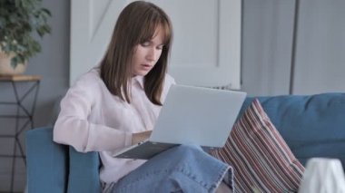 Rahat oturan genç kız kutluyor başarı kullanarak Laptop süre