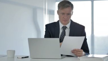 zakenman werken aan documenten en laptop