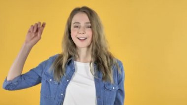 Genç gülümseyen güzel kız sarı arka plan üzerinde dans