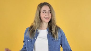 Ağır çekim Genç güzel kızın sarı arka plan üzerinde dans