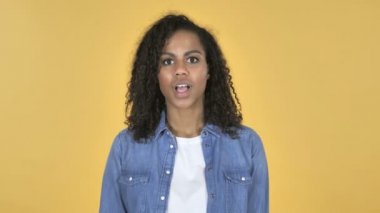 Mutlu hayran Afrikalı kız hediye izole sarı arka plan üzerinde tarafından sürpriz