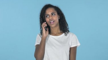 Afrikalı kız üzerinde mavi arka plan izole Smartphone cep telefonu ile konuşmak