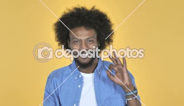 Sarı arka plan üzerinde Afro-Amerikan adam Tamam işareti