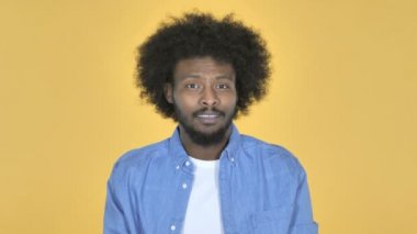 Afro-Amerikan adam sarı arka plan üzerinde çöp için parmak sallayarak