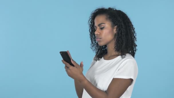 Ragazza Africana Eccitato Successo Durante Utilizzo Smartphone Isolato Sfondo Blu — Video Stock