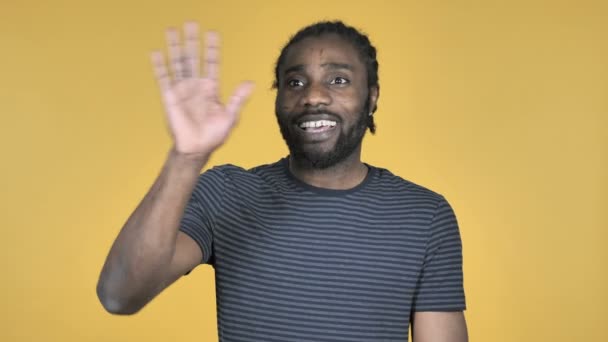 Casual Afrikaanse Man Golvend Hand Aan Welkom Geïsoleerd Gele Achtergrond — Stockvideo