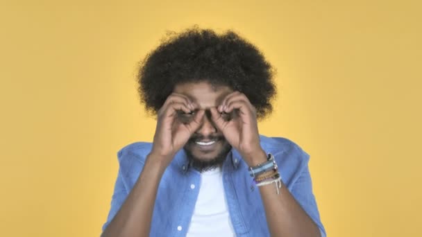 Afroamerikanischer Mann Sucht Mit Handgefertigten Ferngläsern Auf Gelbem Hintergrund — Stockvideo