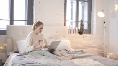 Yatakta heyecanlı Alışveriş Online ödeme başarılı oturan kız