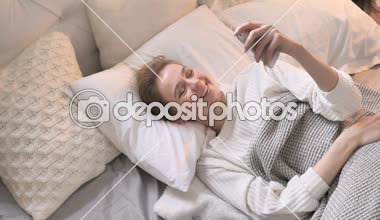 Genç kız yatakta döşeme tarafından Online görüntülü sohbet üstten görünüm