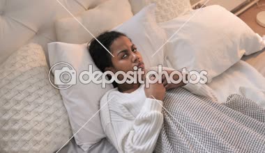 Korkmuş genç Afrikalı kızın şok yatakta döşeme üstten görünüm