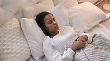 Afrikalı kız yatakta döşeme boyun ağrısı ile üstten görünüm