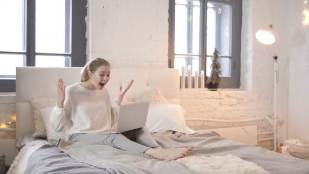 年轻女孩庆祝成功的笔记本电脑 而坐在床上 — 图库视频影像