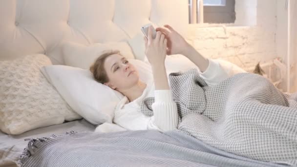 Jong Meisje Met Behulp Van Smartphone Terwijl Leggen Bed — Stockvideo