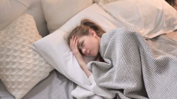 ベッドでスリープ状態にしようとして妨げられた若い女の子のトップ ビュー — ストック動画