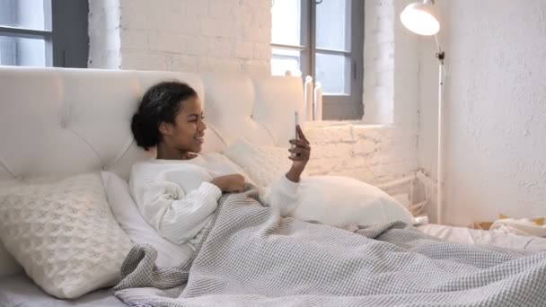 非洲年轻女孩在床上放松的在线视频聊天 — 图库视频影像