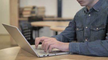 Bir genç yaratıcı adam çalışma üzerinde dizüstü kapatın