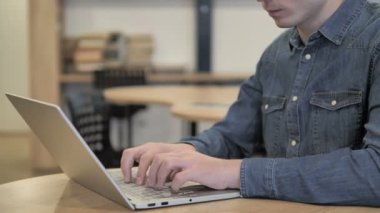 Baş ağrısı, gergin yaratıcı genç dizüstü bilgisayar üzerinde çalışan adam.