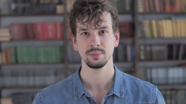 Casual genç adam kameraya bakan gülümseyen portresi