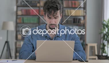 Düşünme ve dizüstü bilgisayarda çalışan dalgın adam