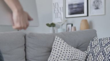 Geliyor ve dizüstü bilgisayar kullanmak için kanepede oturan genç adam