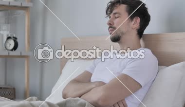 Hasta genç Casual adam yatakta otururken öksürük
