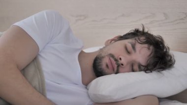 Casual genç adam uyurken yatakta tarafında Lying