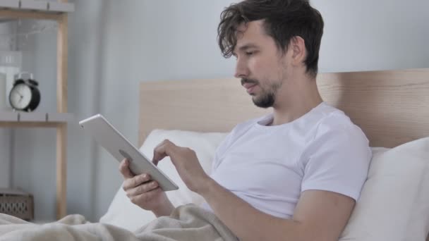 Homem Jovem Usando Tablet Enquanto Deitado Cama — Vídeo de Stock
