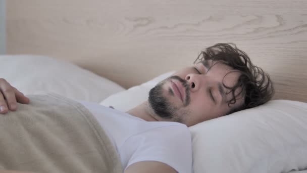 病気若いカジュアルな男咳しながらベッドに横たわる — ストック動画