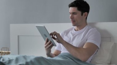 Kaybı için tepki, yatakta Smartphone kullanarak genç adam