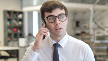 Genç işadamı telefonda konuşuyor.