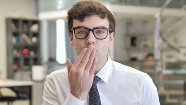 Летающие поцелуи молодого бизнесмена в офисе — стоковое видео