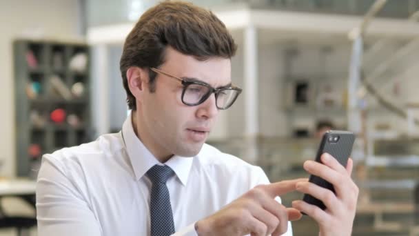 スマートフォンの損失に反応する若いビジネスマン — ストック動画