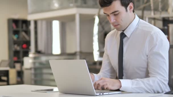 Jovem empresário trabalhando no laptop no escritório — Vídeo de Stock