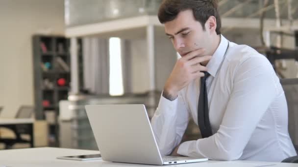 Pensive jeune homme d'affaires Penser et travailler sur ordinateur portable — Video