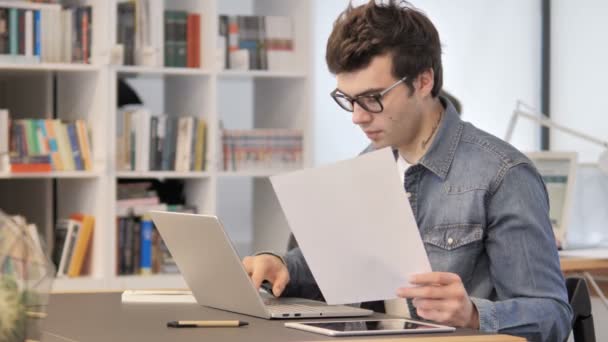 Hombre creativo trabajando en documentos y computadoras portátiles, papeleo — Vídeos de Stock