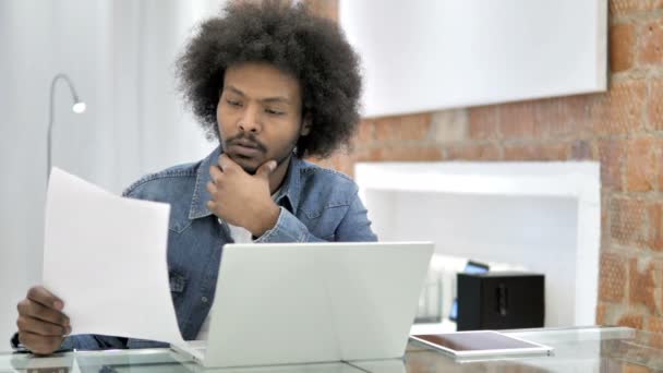 Pensativo africano hombre lectura contrato — Vídeo de stock