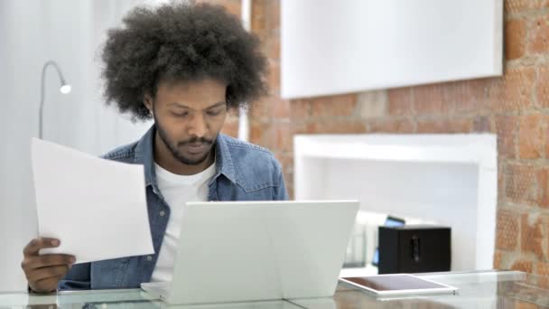 Hombre africano trabajando en documentos en Loft Office — Vídeos de Stock